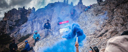 Aficionados del Giro en el paso de Valparola animando al equipo Eolo Kometa con equipaciones y bengalas azules. 
