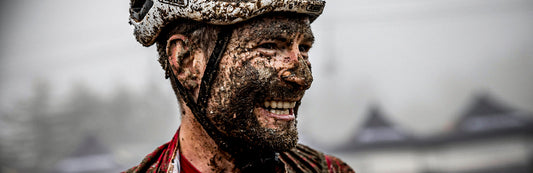 Rabensteiner sonriente al finalizar una carrera. Se muestra su gesto de satisfacción todo cubierto de barro.